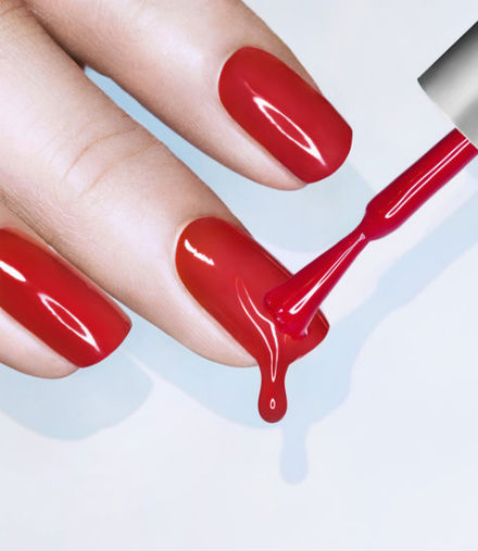 An image of a woman's fingers being painted red.