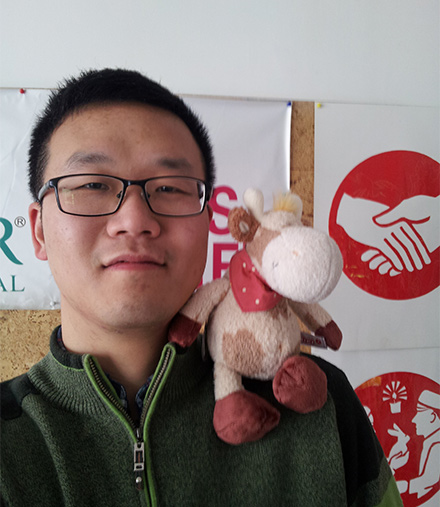 Heifer's Communications officer in China, Tony, poses with a stuffed cow and our Cornerstones in the background. Tony's selfie with stuffed cow