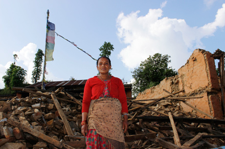 A woman stands in front of her home that collapsed in the April 25 earthquake that struck Nepal. A woman stands in front of her home that collapsed in the April 25 earthquake that struck Nepal.